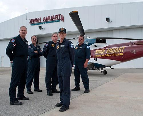 Flight crew standing in front of a Trauma Hawk helicopter