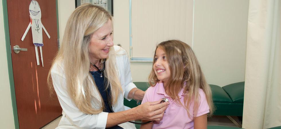 一位学校护士在听一个小女孩的心跳